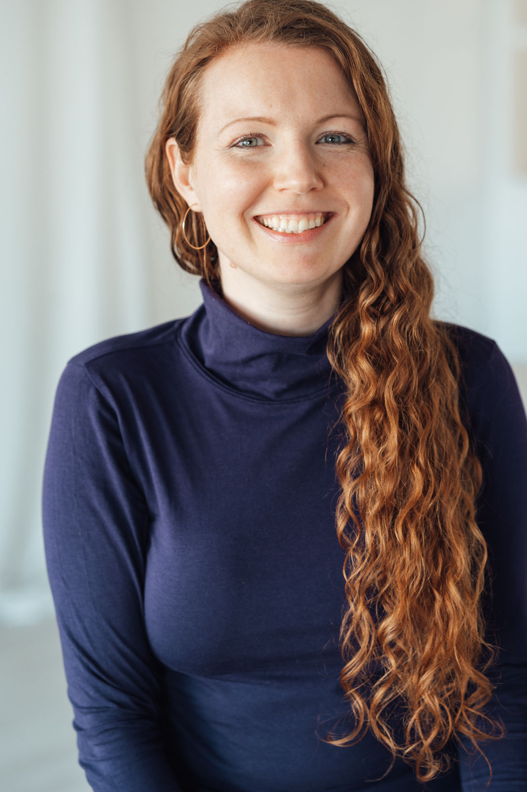 Frau mit Locken lacht fröhlich.